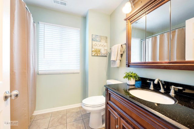 bathroom featuring vanity, plenty of natural light, tile patterned floors, and toilet