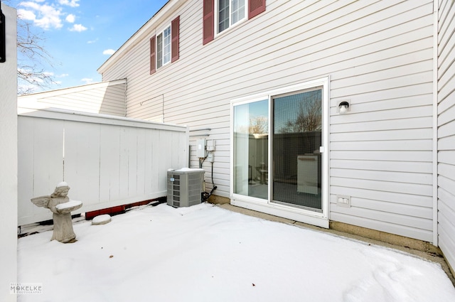 snow covered patio with cooling unit