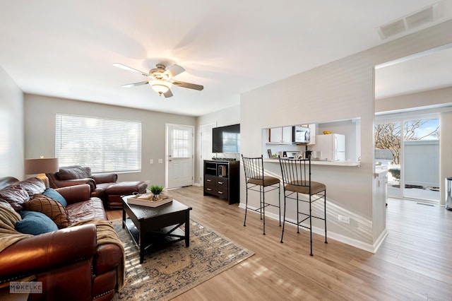 living room with ceiling fan and light hardwood / wood-style flooring