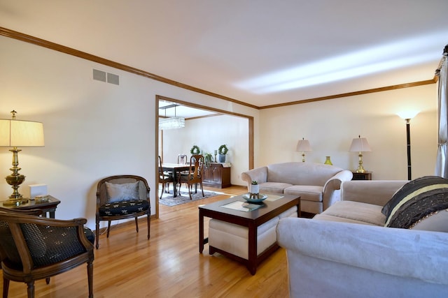 living room with light hardwood / wood-style floors and crown molding