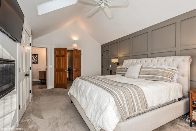 bedroom featuring ceiling fan, lofted ceiling with skylight, and light carpet