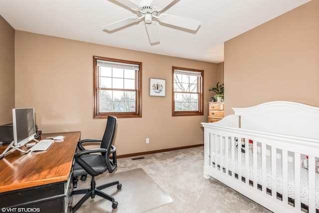 bedroom featuring ceiling fan, a nursery area, and light colored carpet