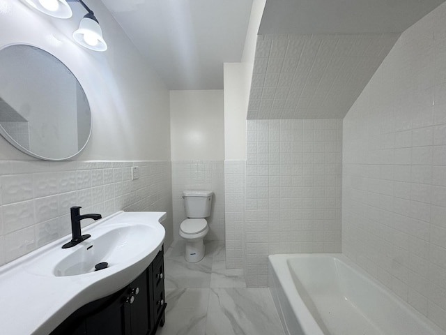 bathroom featuring vanity, toilet, tile walls, and a tub to relax in