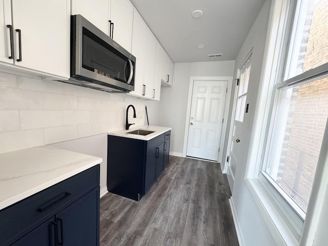 kitchen featuring white cabinets, sink, backsplash, dark hardwood / wood-style floors, and blue cabinetry