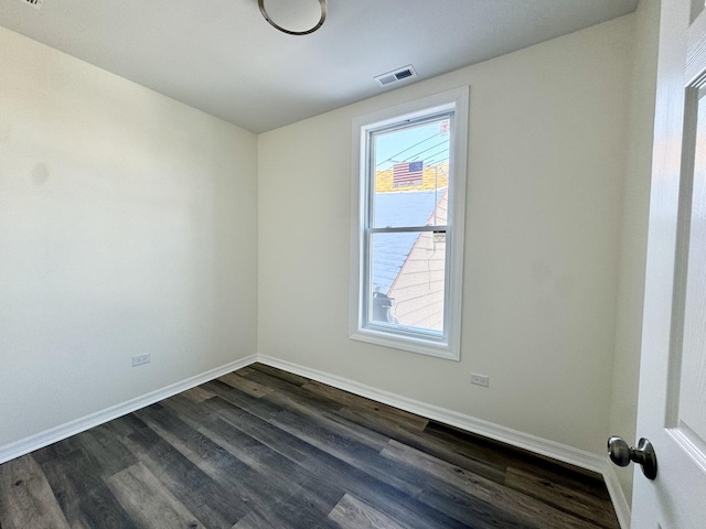 empty room with plenty of natural light and dark hardwood / wood-style floors