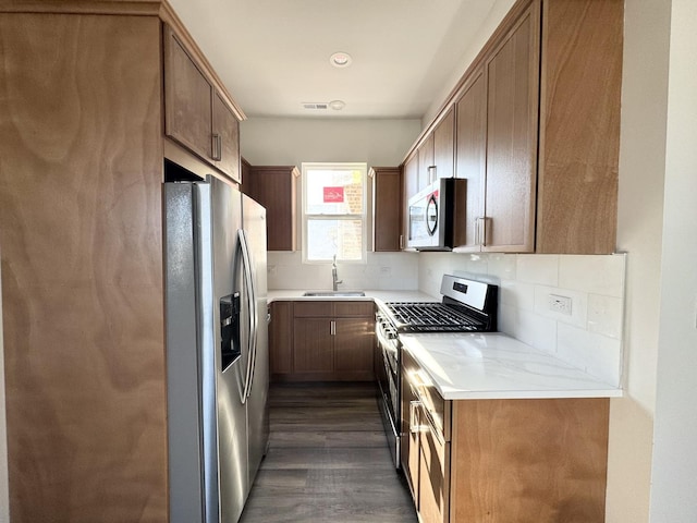 kitchen featuring sink, tasteful backsplash, dark hardwood / wood-style floors, and stainless steel appliances