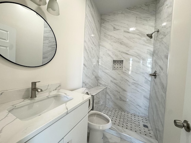 bathroom with vanity, toilet, and a tile shower