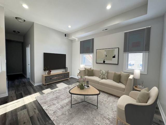 living room with dark wood-type flooring and a healthy amount of sunlight