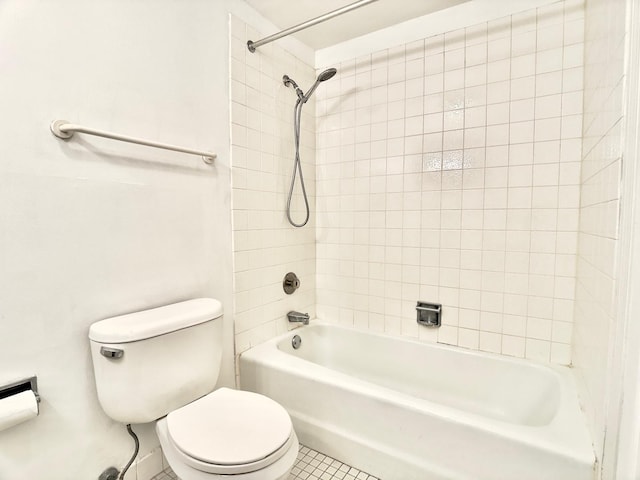 bathroom featuring toilet, tile patterned floors, and tiled shower / bath