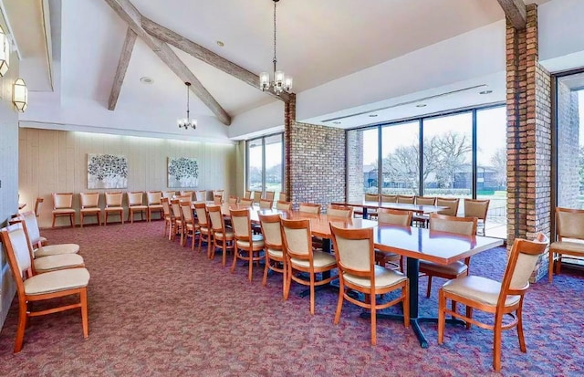 dining space with wood walls, beamed ceiling, a notable chandelier, high vaulted ceiling, and carpet flooring