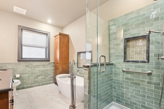 bathroom featuring vanity, shower with separate bathtub, and tile walls