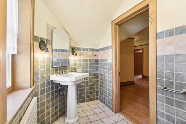 bathroom with vaulted ceiling, tile walls, and tile patterned floors