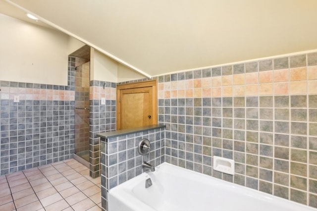 bathroom featuring tile walls, a bathtub, and tile patterned flooring