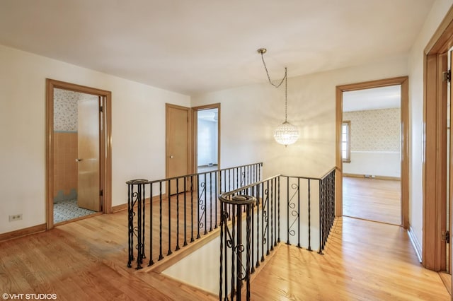 hallway featuring an inviting chandelier and light wood-type flooring