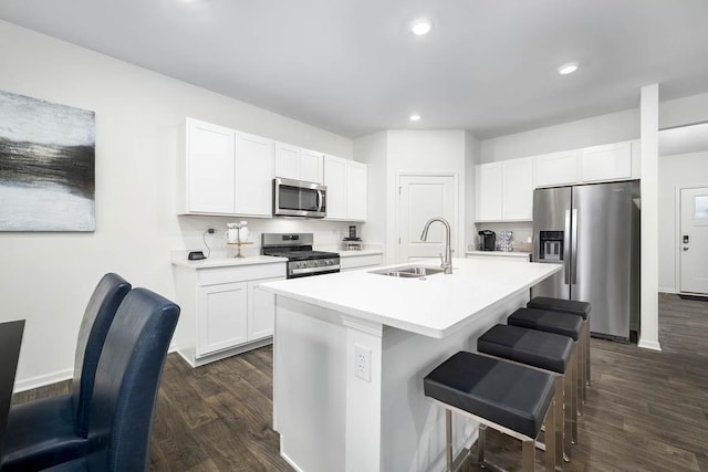 kitchen with dark wood-type flooring, a kitchen island with sink, white cabinetry, appliances with stainless steel finishes, and sink