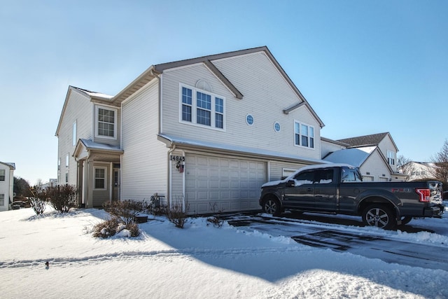 snow covered house with a garage