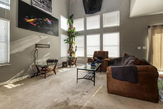 carpeted living room with a towering ceiling