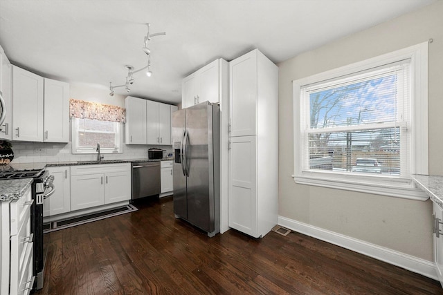 kitchen with sink, white cabinets, backsplash, and appliances with stainless steel finishes