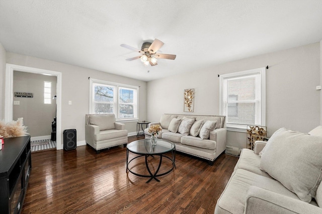 living room featuring ceiling fan and dark wood-type flooring