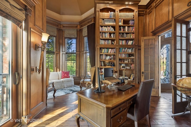 office with dark wood-style floors and built in shelves