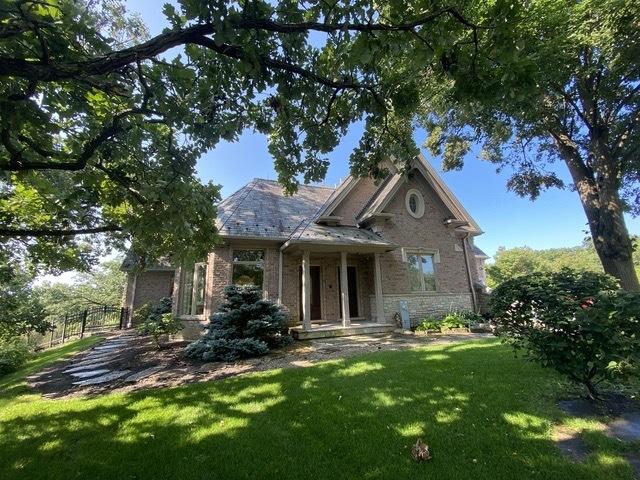 view of front facade with brick siding and a front yard
