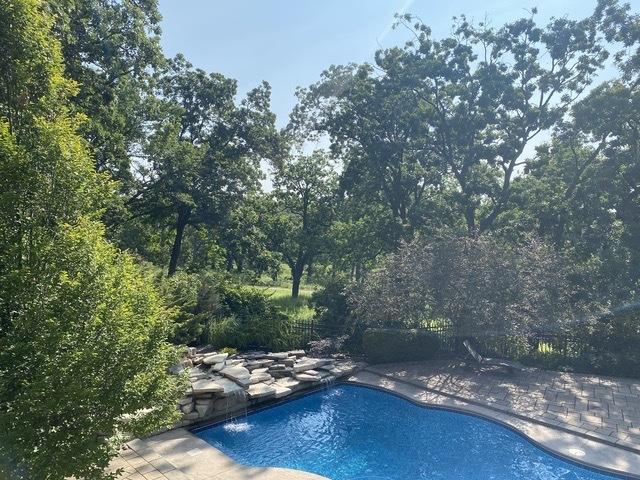 pool with a patio and fence