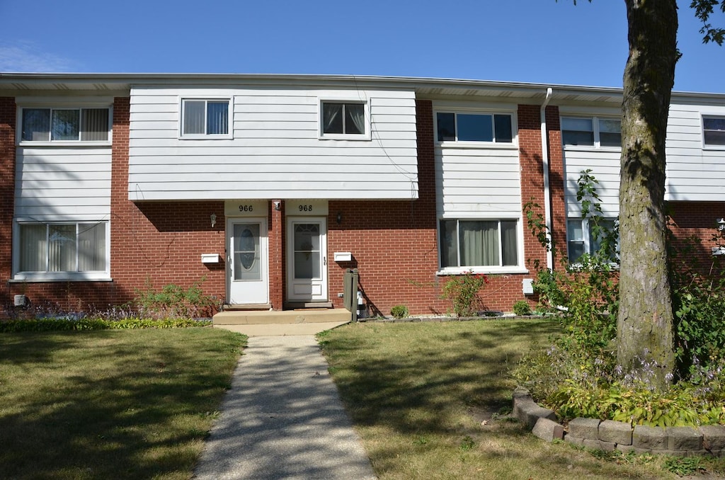 townhome / multi-family property featuring a front yard