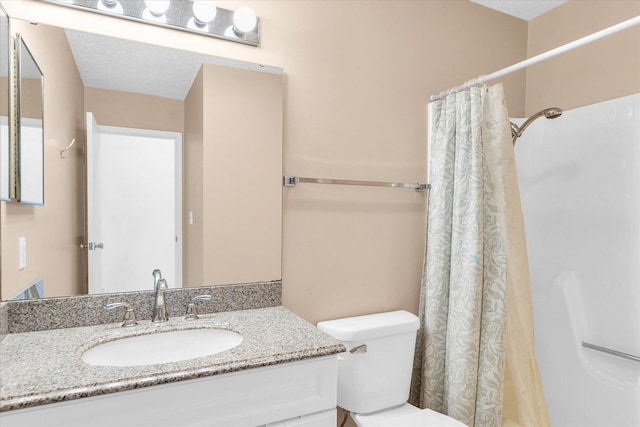 bathroom featuring toilet, a textured ceiling, curtained shower, and vanity