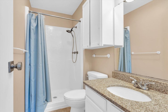 bathroom featuring toilet, vanity, and walk in shower