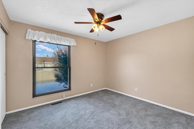 unfurnished room featuring ceiling fan, carpet floors, and a textured ceiling