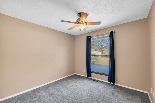 carpeted spare room featuring a textured ceiling and ceiling fan