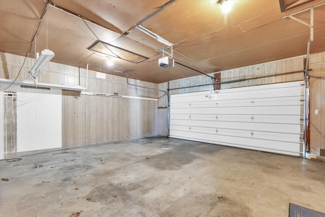 garage with wood walls and a garage door opener