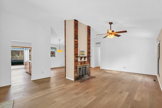 unfurnished living room with ceiling fan, light wood-type flooring, high vaulted ceiling, and a fireplace