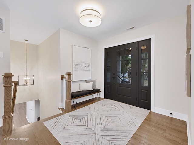 foyer with hardwood / wood-style flooring and a notable chandelier