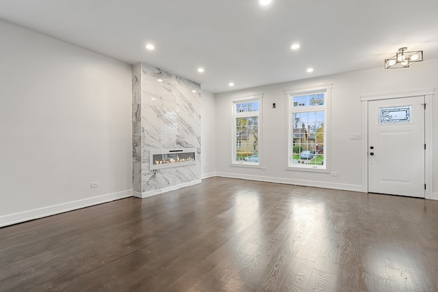 unfurnished living room with a high end fireplace and dark hardwood / wood-style flooring