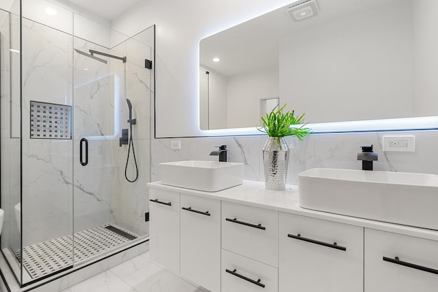 bathroom with tasteful backsplash, vanity, and a shower with shower door