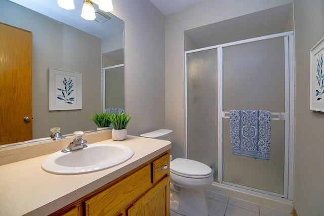 bathroom with toilet, vanity, tile patterned floors, and walk in shower