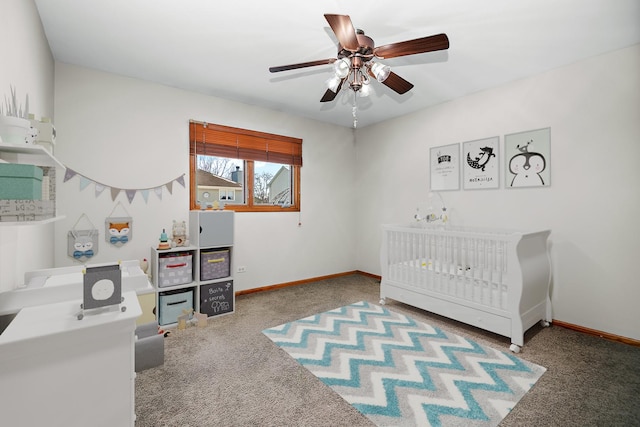 carpeted bedroom with ceiling fan and a crib