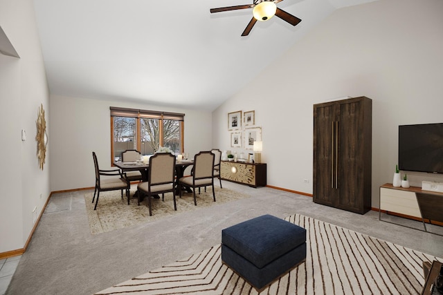 dining room with ceiling fan, high vaulted ceiling, and light carpet