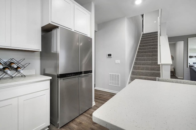 kitchen featuring white cabinets, stainless steel fridge, and dark hardwood / wood-style flooring