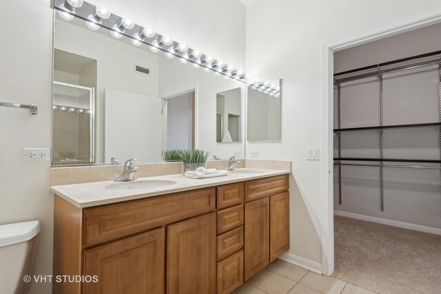 bathroom featuring tile patterned flooring, an enclosed shower, vanity, and toilet