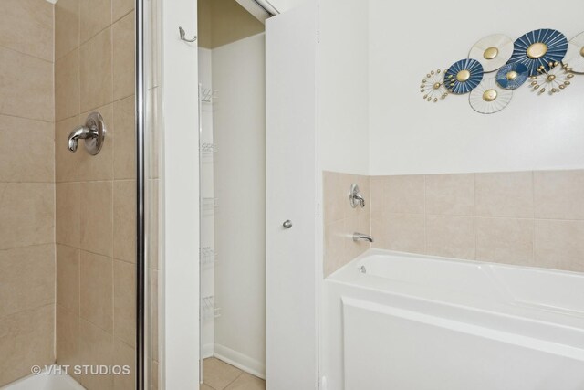 bathroom with shower with separate bathtub and tile patterned floors