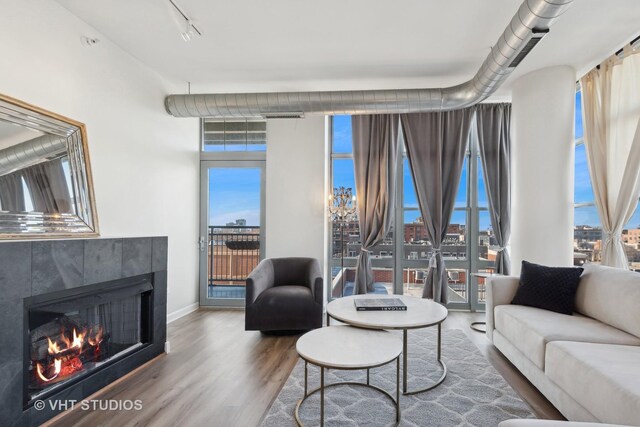 living room with a tile fireplace and wood-type flooring