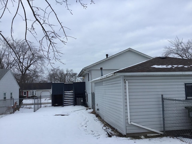 view of snowy exterior with cooling unit