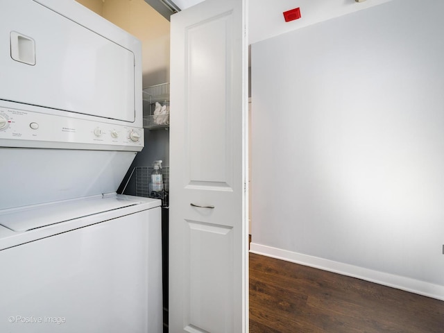 laundry room with stacked washing maching and dryer and dark hardwood / wood-style floors