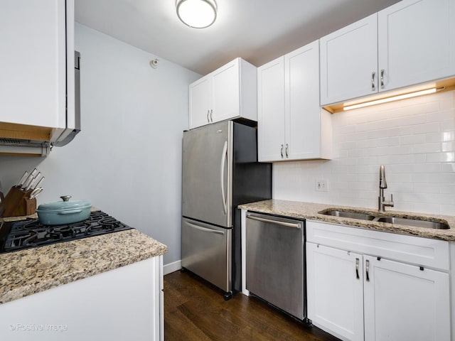 kitchen featuring dark hardwood / wood-style flooring, sink, appliances with stainless steel finishes, white cabinets, and light stone countertops