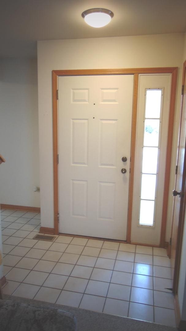 foyer entrance with light tile patterned floors