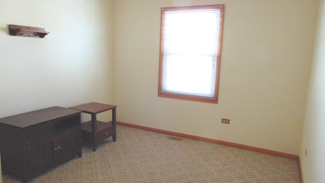 office area featuring light carpet and baseboards