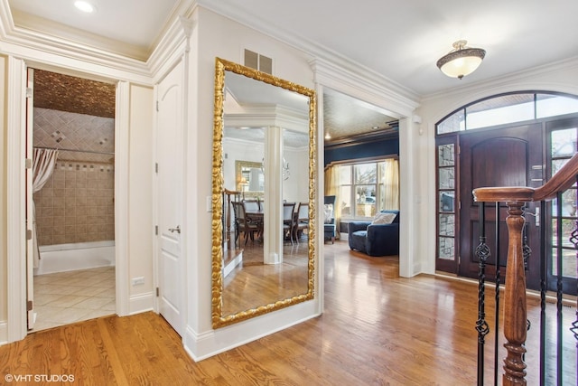 foyer entrance with wood-type flooring and crown molding