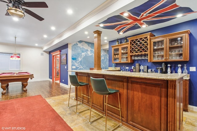 bar with ceiling fan, pool table, light stone counters, and decorative columns